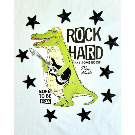 White t-shirt featuring a cartoon crocodile playing a guitar, surrounded by stars and the text "ROCK HARD," "MAKE SOME NOISE," "Play Music," and "BORN TO BE FREE"